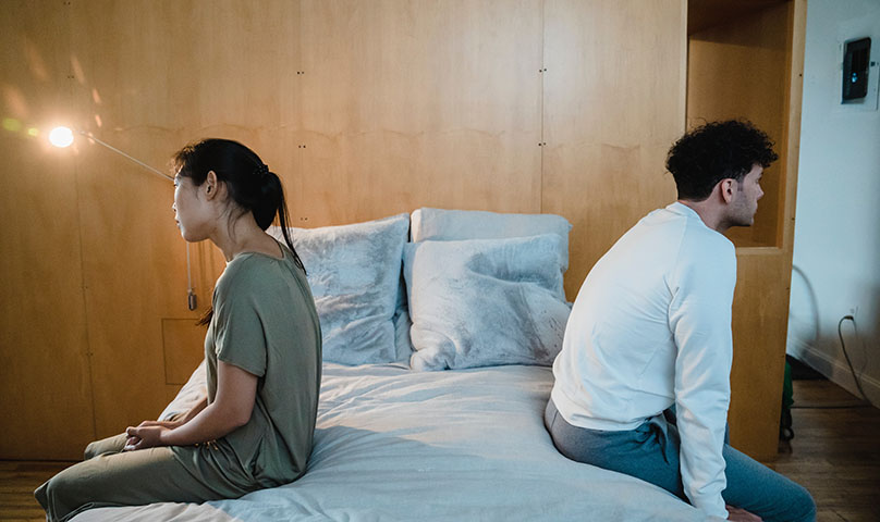 Sad disconnected couple on a bed