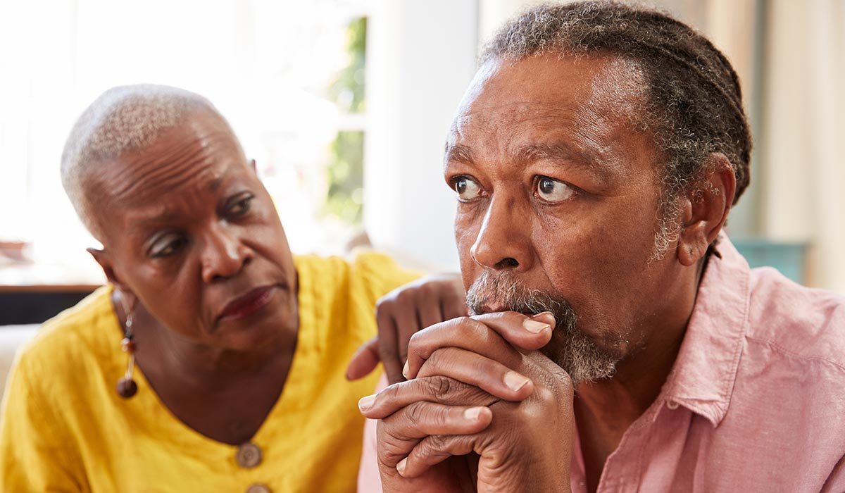 Worried African-Caribbean older man and female partner 