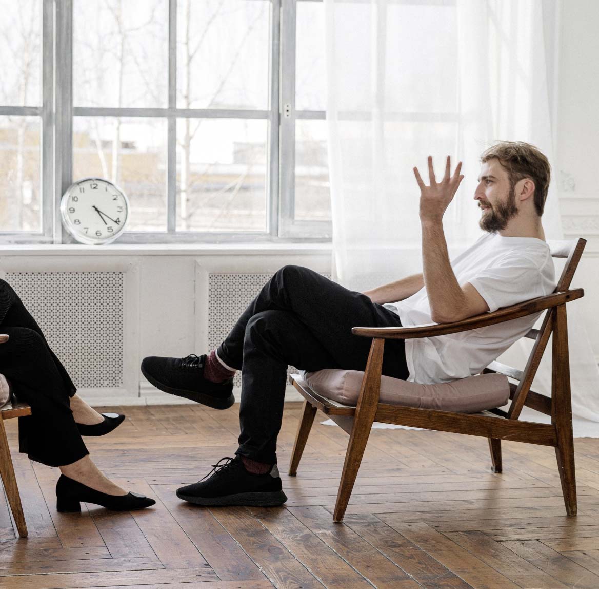 man in a chair talking to a therapist