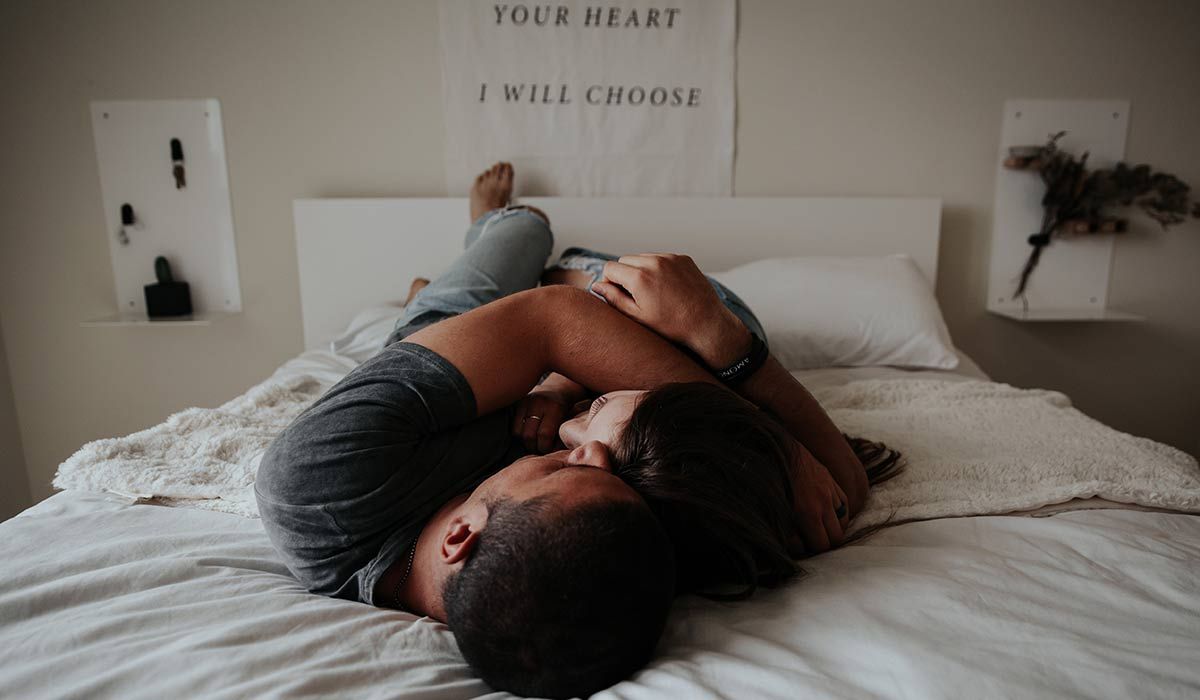 couple hugging each other on a bed
